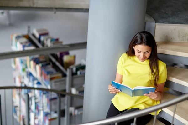 High school student tjej läsebok på bibliotek — Stockfoto