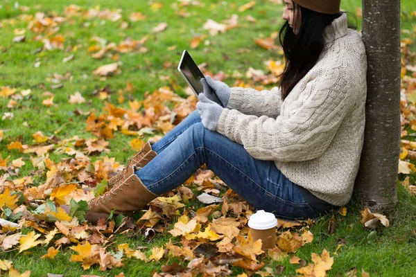 Femme avec tablette pc et café dans le parc d'automne — Photo