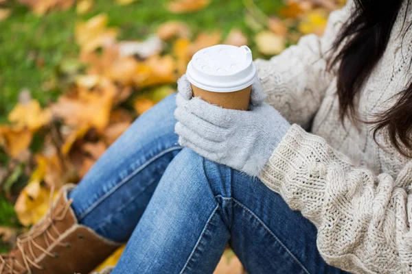 Close up of woman drinking coffee in autumn park — Stock Photo, Image