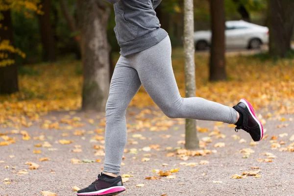 Nahaufnahme einer jungen Frau, die im Herbstpark läuft — Stockfoto