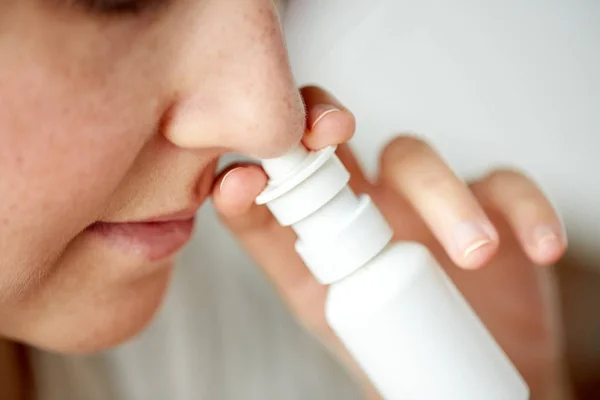 Primer plano de la mujer enferma usando aerosol nasal — Foto de Stock