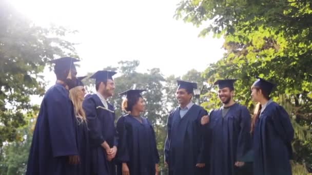 Estudantes felizes jogando placas de argamassa para cima — Vídeo de Stock