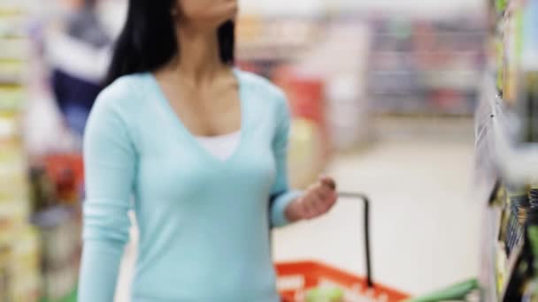 Vrouw leest label op olijfolie fles bij shop — Stockvideo