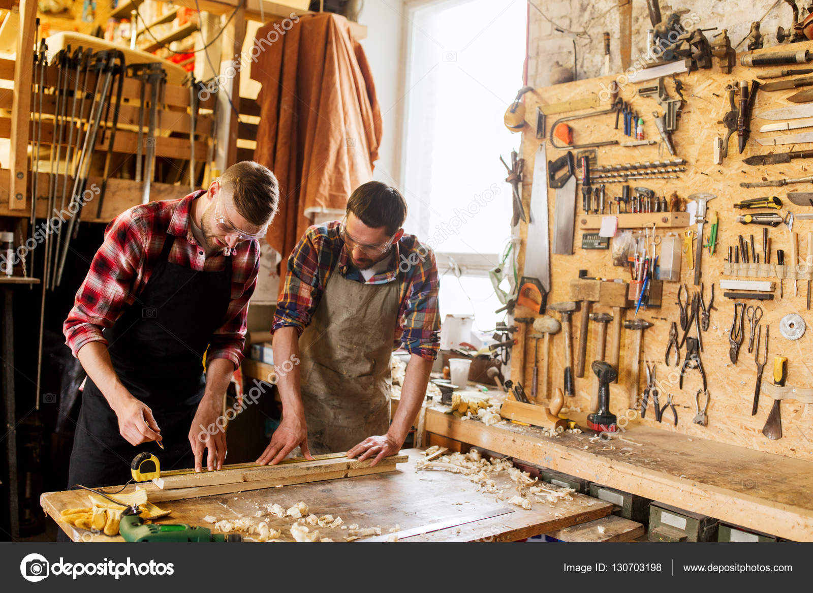 Carpinteros con regla y tablón de madera en el taller fotografía de