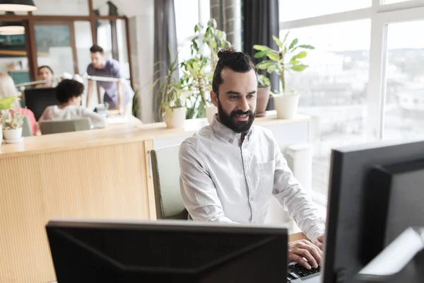 Gelukkig creatieve mannelijke kantoor werknemer met computer — Stockfoto