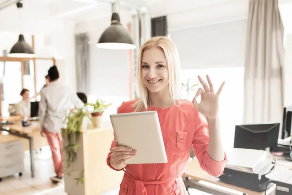 Mulher com tablet pc mostrando sinal ok no escritório — Fotografia de Stock
