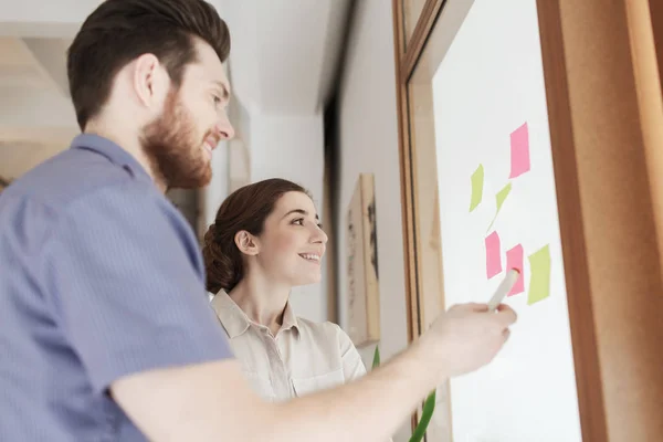 Kreativa team med klistermärken på glas på kontor — Stockfoto