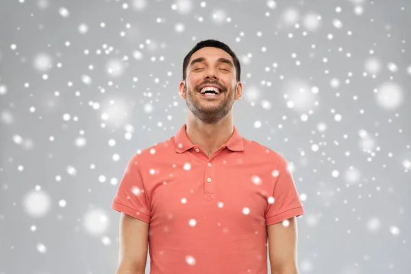 Ευτυχισμένος γελαστός άνθρωπος πέρα από το χιόνι υπόβαθρο — Φωτογραφία Αρχείου
