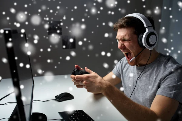 Homem em fone de ouvido jogando jogo de computador em casa — Fotografia de Stock