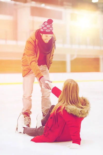 Hombre ayudando a las mujeres a levantarse en pista de patinaje —  Fotos de Stock