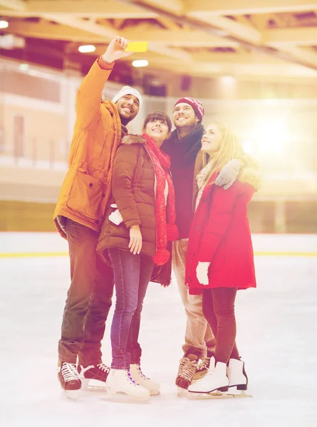 Amigos felices tomando selfie en pista de patinaje —  Fotos de Stock