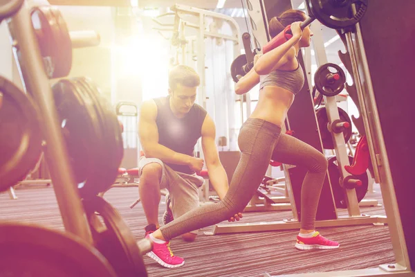 Hombre y mujer con los músculos de flexión de la barra en el gimnasio — Foto de Stock