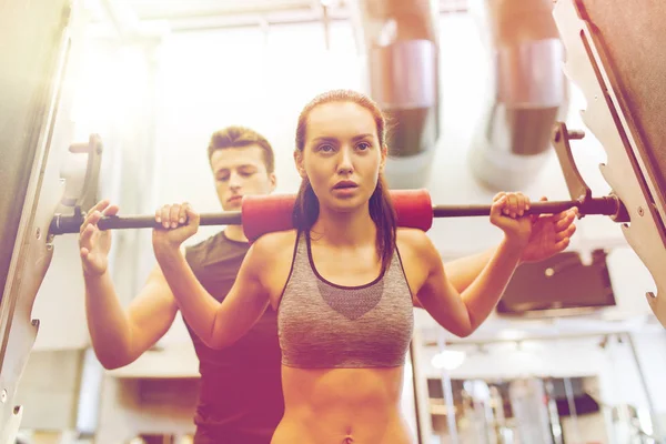 Hombre y mujer con los músculos de flexión de la barra en el gimnasio —  Fotos de Stock