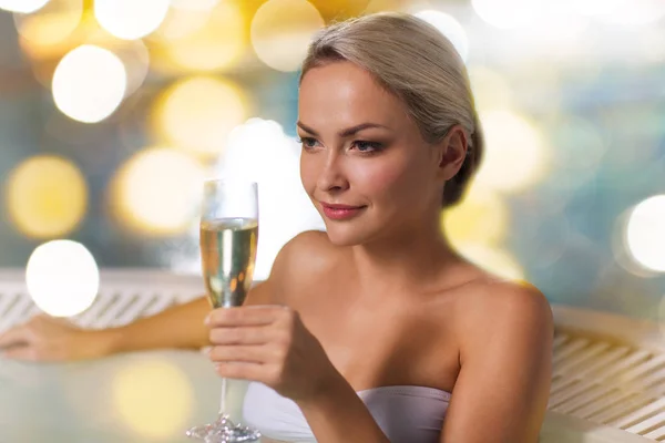 Glückliche Frau trinkt Champagner im Schwimmbad — Stockfoto