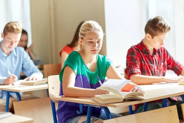 Groupe d'étudiants avec des livres écrit test scolaire — Photo