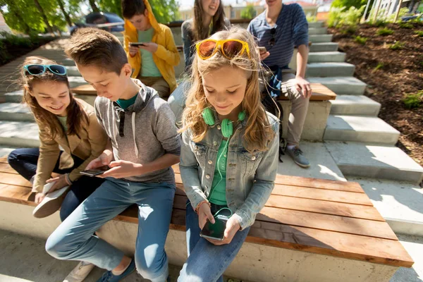 Groupe d'amis adolescents avec smartphones en plein air — Photo