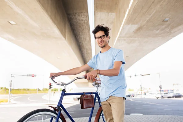 Хипстерский человек с фиксированной передачей велосипед под мостом — стоковое фото