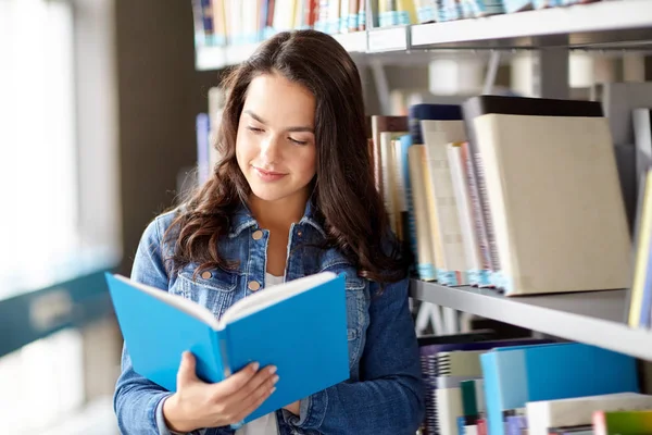 Lise öğrencisi kız Kütüphanesi'nde kitap okumak — Stok fotoğraf