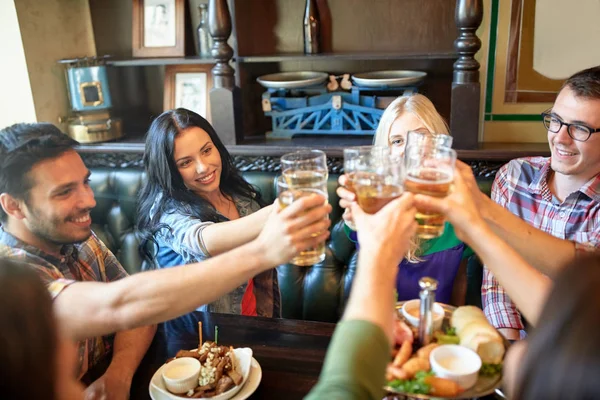 Amigos felices bebiendo cerveza en el bar o pub — Foto de Stock