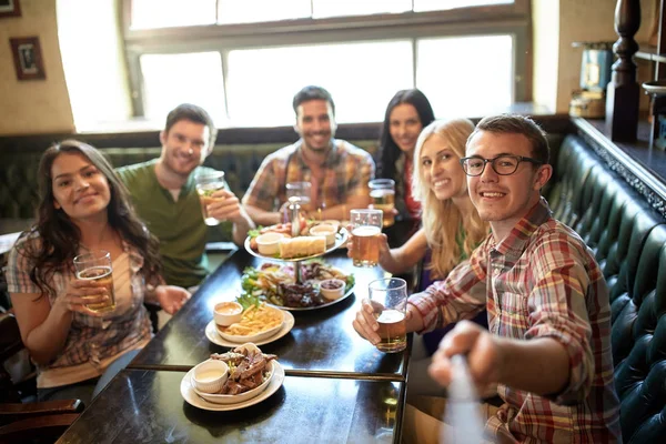 Glückliche Freunde mit Selfie-Stick in Bar oder Kneipe — Stockfoto