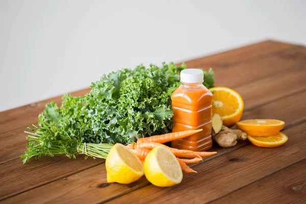 Bouteille avec jus de carotte, fruits et légumes — Photo