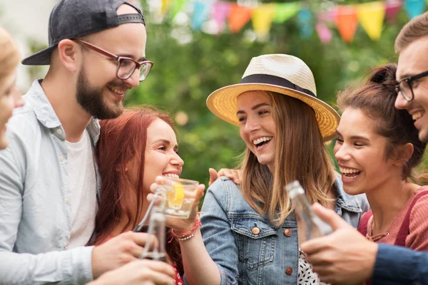 Happy friends clinking glasses at summer garden — Stock Photo, Image