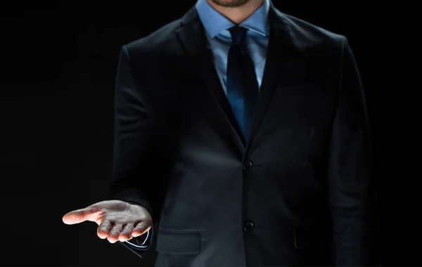 Close up of businessman holding something on hand — Stock Photo, Image