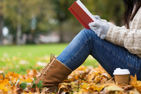 本书在秋天公园里喝咖啡的女人 — 图库照片