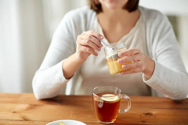 벌 꿀 차를 마시는 병 여자의 클로즈업 — 스톡 사진