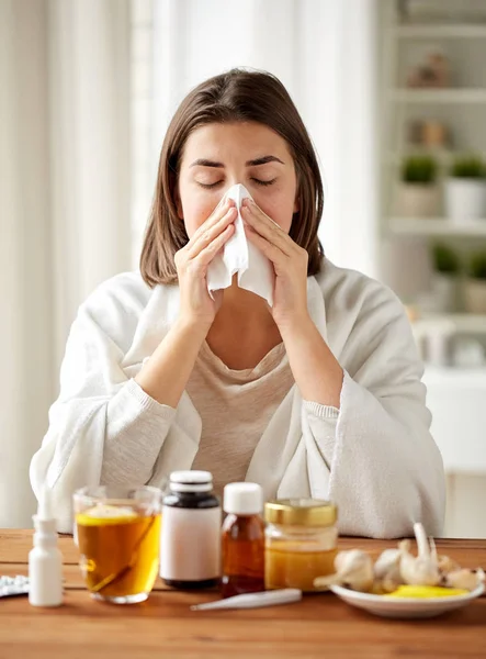 Zieke vrouw met medicijnen snuit neus af te vegen — Stockfoto