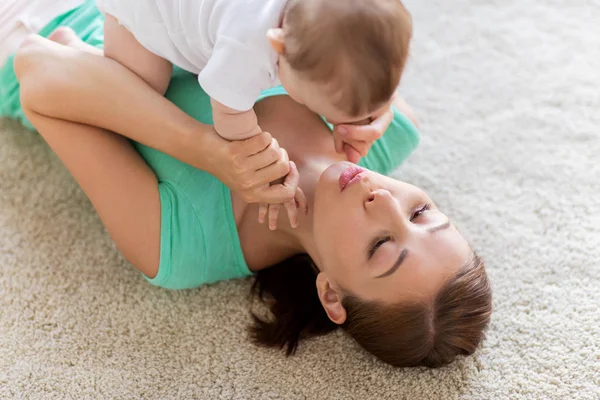 Lycklig mamma leker med liten bebis hemma — Stockfoto