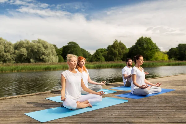 Люди, медитирующие в йога-лотос, позируют на открытом воздухе — стоковое фото