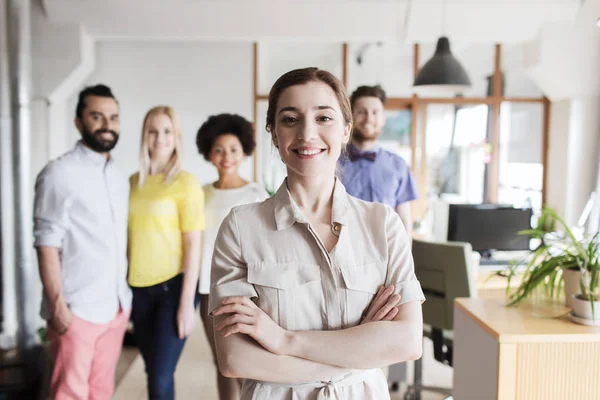 Glad ung kvinna över kreativt team på kontoret — Stockfoto