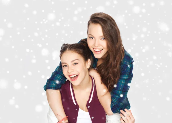 Glücklich lächelnde Teenager-Mädchen, die sich über Schnee umarmen — Stockfoto