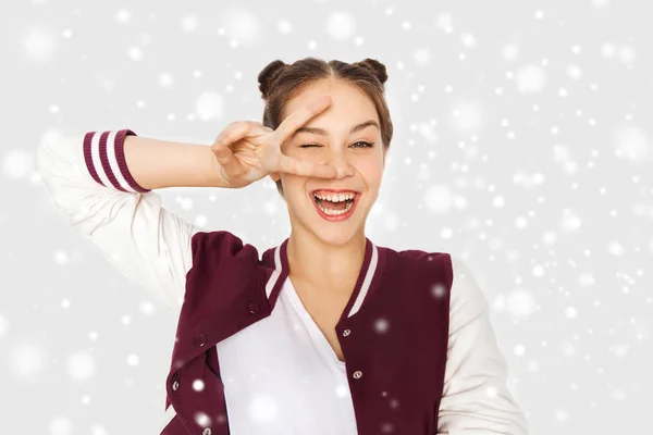 Menina adolescente feliz mostrando sinal de paz sobre a neve — Fotografia de Stock