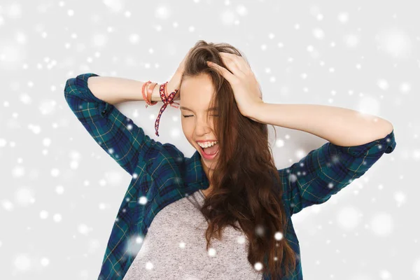 Glad tonårsflicka hålla huvudet över snö — Stockfoto