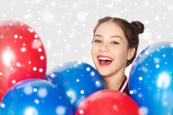 Счастливая девочка-подросток с гелиевыми шариками над снегом — стоковое фото