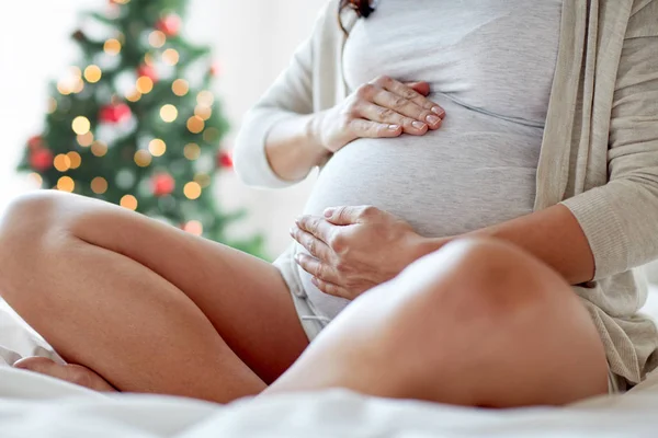 Закрыть беременную женщину, сидящую в постели дома — стоковое фото