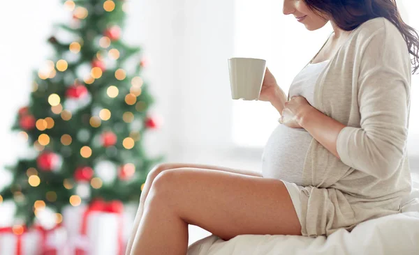 Närbild av gravid kvinna med te kopp hemma — Stockfoto