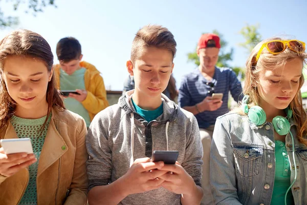 Skupina dospívajících přátel s smartphony venku — Stock fotografie