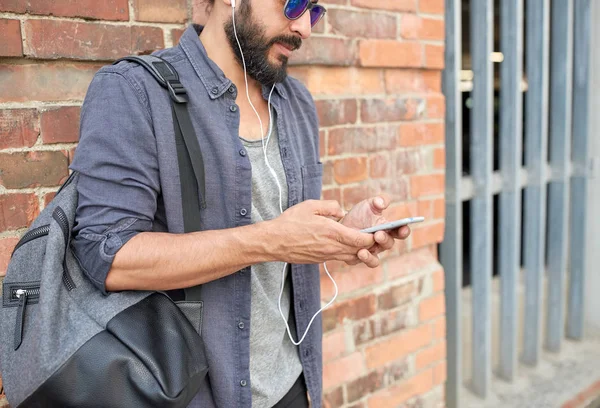 Man with earphones, smartphone and bag on street — Stock Photo, Image