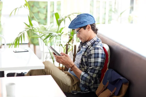 Człowiek z komputera typu tablet, siedząc przy stoliku kawiarnianym — Zdjęcie stockowe
