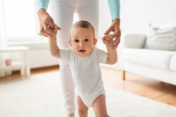 happy baby learning to walk with mother help