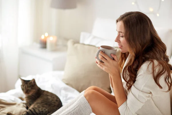 Mujer feliz con taza de café en la cama en casa —  Fotos de Stock