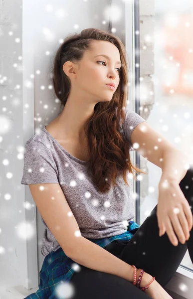 Trauriges hübsches Teenager-Mädchen sitzt auf Fensterbank — Stockfoto