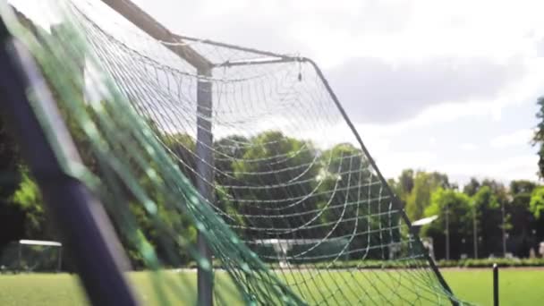 Ball flying into football goal net on field — Stock Video