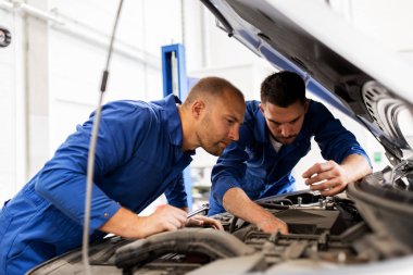 mechanic men with wrench repairing car at workshop clipart