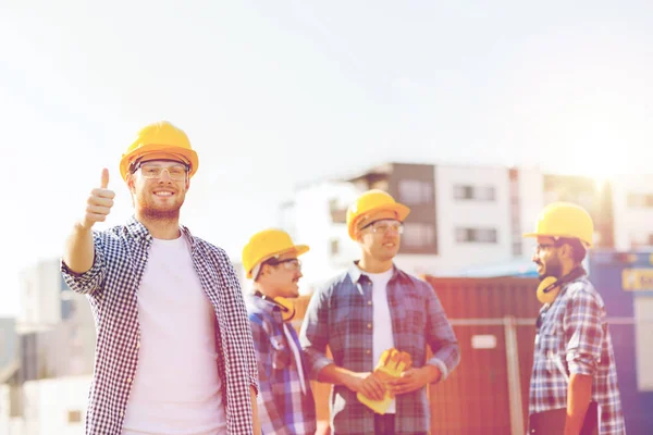 Grupa budowniczych uśmiechający się w hardhats na zewnątrz — Zdjęcie stockowe