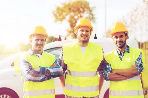 Ομάδα των χαμογελαστά οικοδόμων στο hardhats υπαίθρια — Φωτογραφία Αρχείου