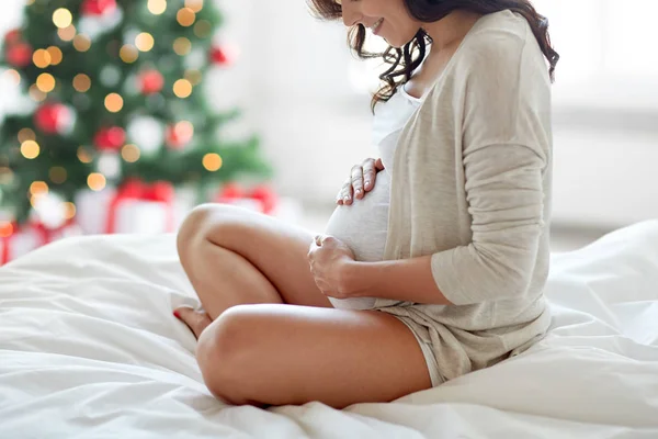 Primer plano de la mujer embarazada en la cama en Navidad —  Fotos de Stock